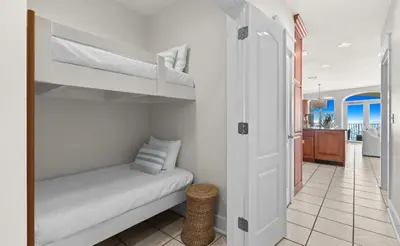 a bedroom with two bunk beds and a hallway at Front Row in Inlet Beach