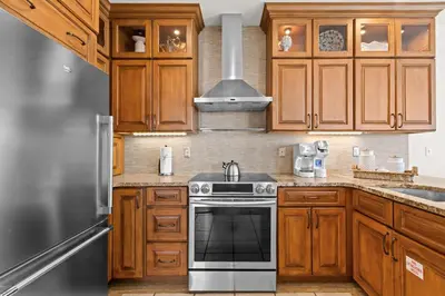 a kitchen with wooden cabinets and a stove top oven at Front Row in Inlet Beach