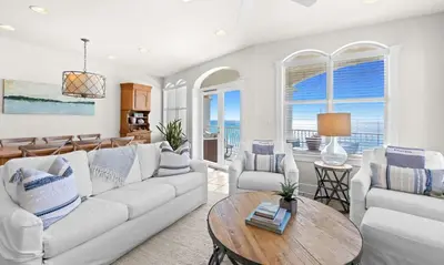 a living room with a couch and chairs and a table at Front Row in Inlet Beach