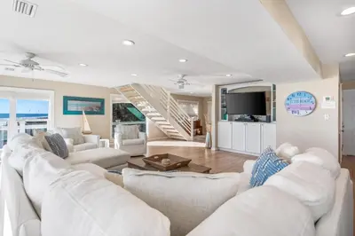 a living room with white couches and a tv at Kokomo in Santa Rosa Beach