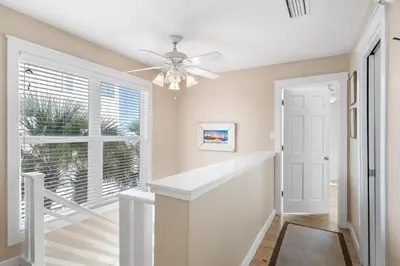 a hallway with a staircase and a ceiling fan at Kokomo in Santa Rosa Beach