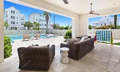 a patio with wicker chairs and a pool at SEAcret to Life in Inlet Beach