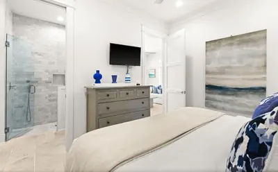 a bedroom with a bed and a tv on a wall at SEAcret to Life in Inlet Beach