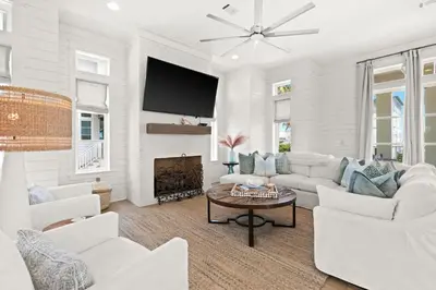 a living room with white furniture and a flat screen tv at SEAcret to Life in Inlet Beach