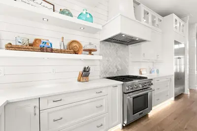 a kitchen with white cabinets and a stove at SEAcret to Life in Inlet Beach