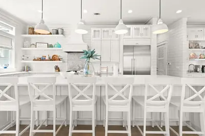 a white kitchen with a large white table and chairs at SEAcret to Life in Inlet Beach