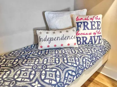 a bed with a blue and white blanket and two pillows at Rosie Disposition in Santa Rosa Beach