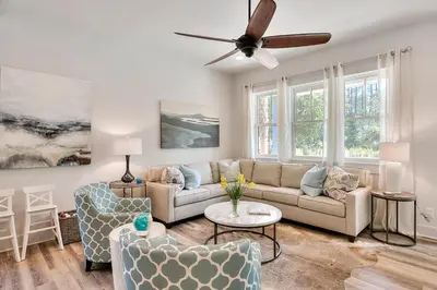 a living room with a couch and a ceiling fan at Rosie Disposition in Santa Rosa Beach
