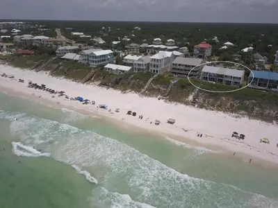 an aerial view of a beach with a group of people at The Good Life in Inlet Beach