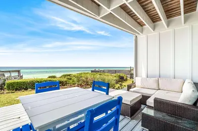 a patio with a table and chairs and the ocean at The Good Life in Inlet Beach