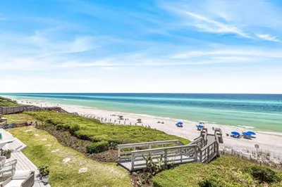 a view of a beach with umbrellas and the ocean at The Good Life in Inlet Beach