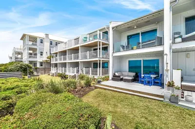 an exterior view of a large white apartment building at The Good Life in Inlet Beach