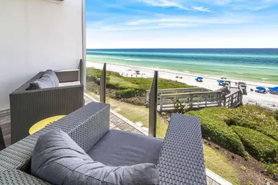 a balcony with a couch and a view of the beach at The Good Life in Inlet Beach