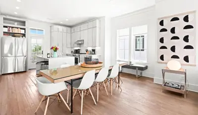 a white kitchen with a wooden table and chairs at Moonstruck in Santa Rosa Beach