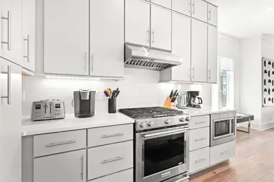 a kitchen with white cabinets and a stove top oven at Moonstruck in Santa Rosa Beach