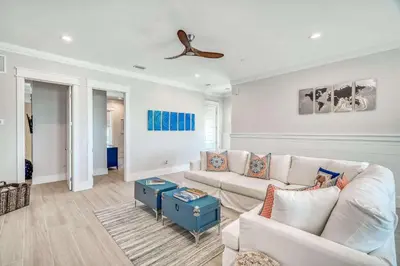 a living room with a couch and a ceiling fan at The Sundowner in Panama City Beach