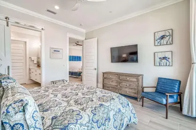 a bedroom with a bed and a chair and a tv at The Sundowner in Panama City Beach