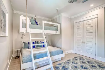a room with bunk beds and a ladder at The Sundowner in Panama City Beach