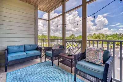 a screened porch with chairs and a table with a view at Saltwater Dreams in Santa Rosa Beach