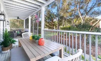 a porch with a wooden table and chairs at Flamingo Key in Santa Rosa Beach