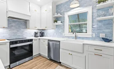 a kitchen with white cabinets and a sink at Flamingo Key in Santa Rosa Beach