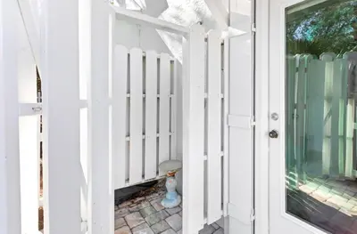 a white door leading to a porch with a fire hydrant at Flamingo Key in Santa Rosa Beach