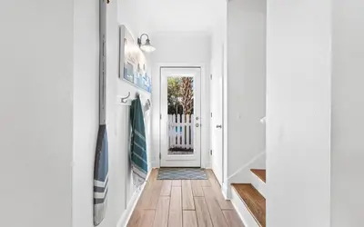 a hallway of a home with white walls and wood floors at Flamingo Key in Santa Rosa Beach