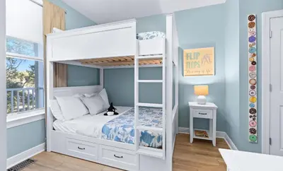 a white bunk bed in a room with blue walls at Flamingo Key in Santa Rosa Beach