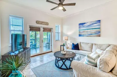 a living room with a couch and a flat screen tv at Grove Getaway in Santa Rosa Beach