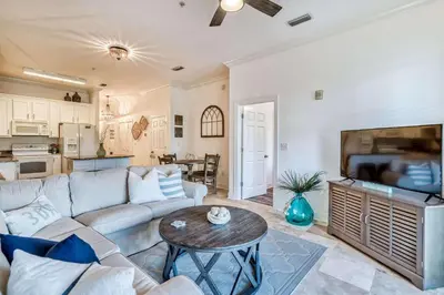 a living room with a couch and a table at Grove Getaway in Santa Rosa Beach