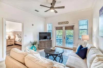 a living room with a couch and a tv at Grove Getaway in Santa Rosa Beach