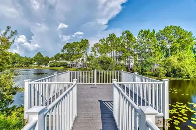 a white boardwalk over a river with trees at Grove Getaway in Santa Rosa Beach