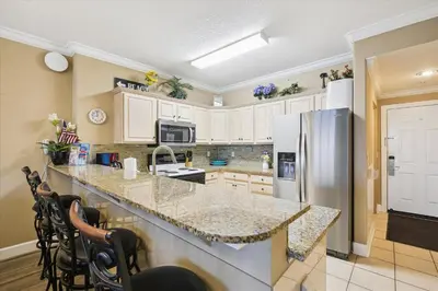 a kitchen with white cabinets and a granite counter top at Twin Palms Resort #1502 by Book That Condo in Panama City Beach