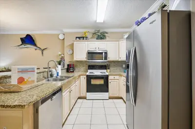 a kitchen with white cabinets and a refrigerator at Twin Palms Resort #1502 by Book That Condo in Panama City Beach