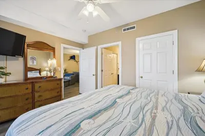 a bedroom with a bed and a dresser and a television at Twin Palms Resort #1502 by Book That Condo in Panama City Beach