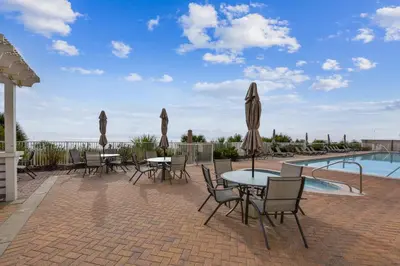 a patio with tables and chairs next to a pool at Twin Palms Resort #1502 by Book That Condo in Panama City Beach