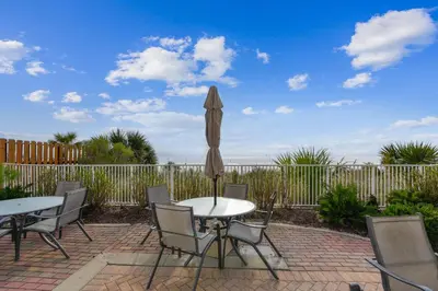 a patio with two tables and an umbrella at Twin Palms Resort #1502 by Book That Condo in Panama City Beach