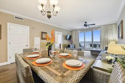 a dining room and living room with a table and chairs at Twin Palms Resort #1502 by Book That Condo in Panama City Beach
