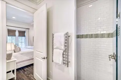 a bathroom with a walk in shower next to a bedroom at Seabourn in Santa Rosa Beach