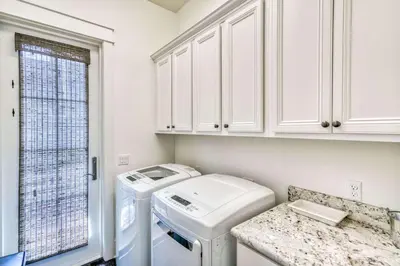 a white laundry room with a washer and dryer at Seabourn in Santa Rosa Beach