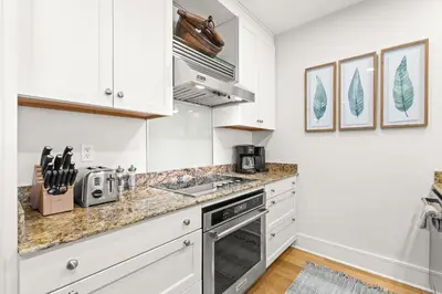 a kitchen with white cabinets and a counter top at Jewel Box at Watersound in Inlet Beach