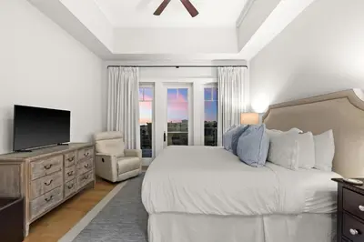 a bedroom with a bed and a tv and a window at Jewel Box at Watersound in Inlet Beach