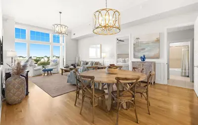 a dining room and living room with a table and chairs at Jewel Box at Watersound in Inlet Beach