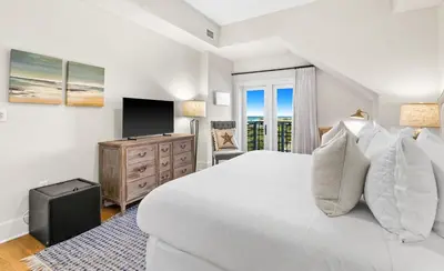 a bedroom with a white bed and a television at Jewel Box at Watersound in Inlet Beach