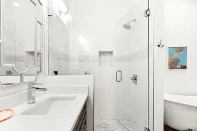 a white bathroom with a sink and a shower at The Sun Kiss in Santa Rosa Beach