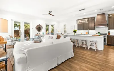a living room with a white couch and a kitchen at The Sun Kiss in Santa Rosa Beach