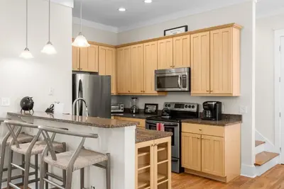 a kitchen with wooden cabinets and stainless steel appliances at Blue Heaven in Santa Rosa Beach