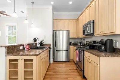 a kitchen with wooden cabinets and a stainless steel refrigerator at Blue Heaven in Santa Rosa Beach