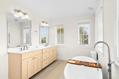 a white bathroom with a tub and a large mirror at Blue Heaven in Santa Rosa Beach