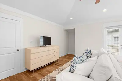 a white living room with a white couch and a tv at Blue Heaven in Santa Rosa Beach